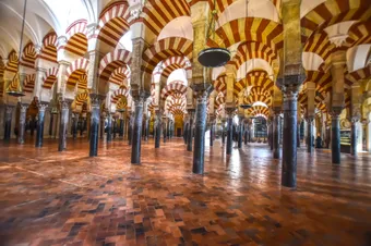Forêt de colonnes et arches rouges et blanches de la cathédrale de Cordoue, héritage spectaculaire de l’ancienne grande mosquée.