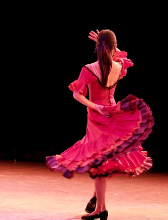 Danseuse de flamenco en robe rouge tourbillonnante, capturant la passion et l’énergie de la danse andalouse. À Séville, le flamenco fait partie intégrante de l’identité culturelle et des traditions musicales de la ville.