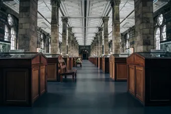 Elegant view of a museum hallway with symmetrical columns and wood displays.