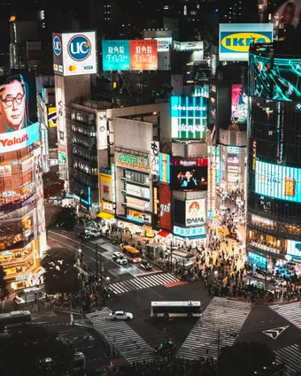 Explore the bustling Shibuya Crossing in Tokyo, Japan, illuminated by vibrant city lights at night.