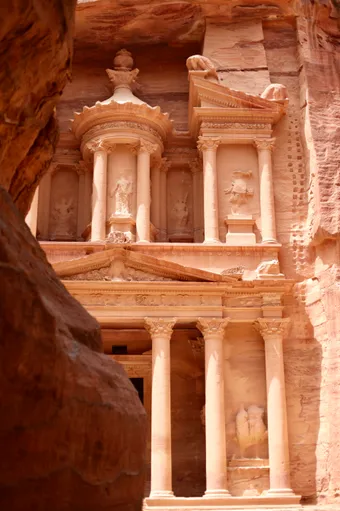 Carved facade of Petra’s Treasury cut into pink sandstone rock
