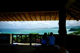 The coast of Ishigaki Island reveals pale sandy beaches fringed by turquoise waters and coral reefs, where layers of blue melt into the horizon. Between mangroves, gentle cliffs, and lush tropical vegetation, the scenery creates an atmosphere that feels both wild, peaceful, and truly exotic.