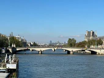 Stunning view of a classic Parisian bridge spanning the Seine River under a clear blue sky.