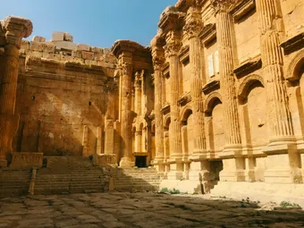The interior of the temple showcases monumental architecture with richly carved columns and impressive proportions. The decorated walls and natural light highlight the remarkable refinement of ancient Roman craftsmanship.