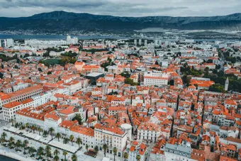 Stunning aerial shot of Split, Croatia, showcasing historic architecture and vibrant rooftops against a mountain backdrop.